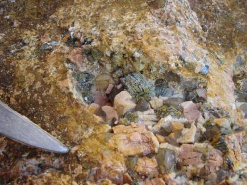 A typical cavity found at the blocks that are temporarily stored in the quarry. Note the Carlsbad twin in microcline, surrounded by many other small quartz, albite and muscovite (Author: davidsoler)