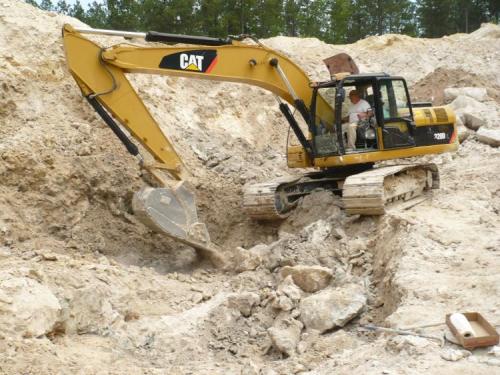 Track hoe, very useful for moving waste rock and for breaking up the granite. (Author: John S. White)