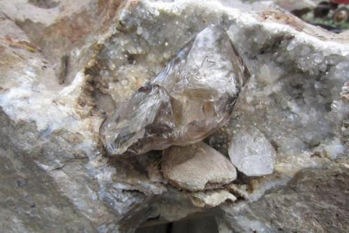 12 cm. quartz with a smaller friend, rests on an eatched calcite crystal and quartz druze. (Author: vic rzonca)