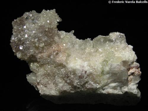 Apofilita-(KF)(Fluorapofilita)
Cantera La Dehesilla, plutón de La Cabrera, Sieteiglesias, Loyozuela-Navas-Sieteiglesias, Madrid, España
7 x 5 x 2 cm.
Grupo de pequeños cristales brillantes algunos con inclusiones de hematites, sobre una matriz de ortoclasa rosada. (Autor: Frederic Varela)