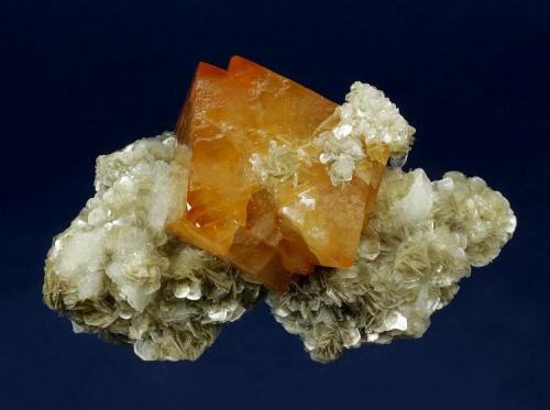 Scheelite on Muscovite
Mt. Xuebaoding, Pingwu County, Mianyang Prefecture, Sichuan Province, China
101 x 68 x 40 mm

Fiery-orange Scheelite measuring 55 x 43 mm is perched a sculptural matrix of Muscovite, accented by small gemmy Qyartz crystals.  Several nice rosettes of Muscovite are perched atop the Scheelite.  Absolutely pristine. (Author: GneissWare)
