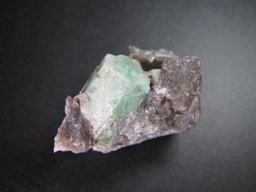 Berilo
Carnaiba Mine, Pindobaçu, Campo Formoso, Bahia, Brasil
3’5 x 2’5 cm.
Un prisma de berilo verde con base hexagonal elongada.  La matriz parece cuarzo masivo grisáceo, o una cuarcita de aspecto sacaroideo. (Autor: prcantos)