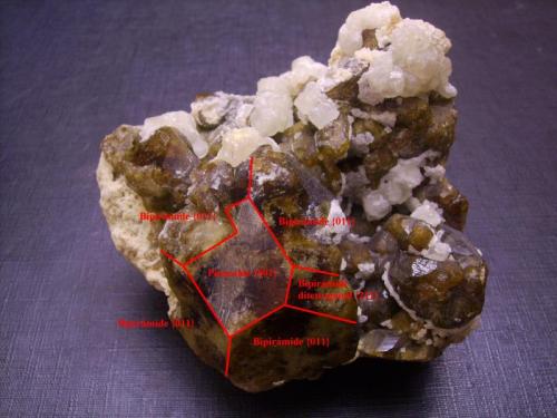 Vesubianita, calcita
Fushan Mine, She Co., Handan Prefecture, Hebei Province, China
6 x 6 x 4,5 cm
Indicación de las caras. Los cristales, como los que son flotantes del mismo yacimiento, son bipirámides tetragonales con pinacoide como en este caso. Aparece también una sola cara de una pirámide ditetragonal (que de aparecer todas nos daría una bipirámide de ocho caras arriba y ocho abajo en lugar de cuatro y cuatro como en este caso). Tengo un cristal flotante en el que el pinacoide aparece sólo rematando una pirámide, por abajo la terminación es en punta. (Autor: Antonio Alcaide)