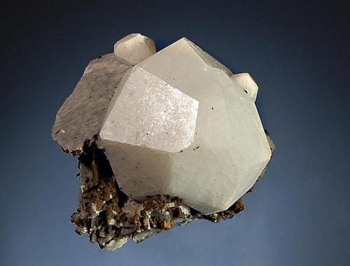 Analcime
Poudrette Quarry, Mont Saint-Hilaire, Monteregie, Quebec, Canada
4.0 x 4.7 cm.
Well-formed dodecahedral crystal of analcime measuring associated with brown siderite and bladed gray albite. (Author: crosstimber)