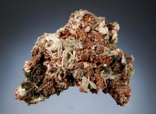 Rhodochrosite
Mont Saint-Hilaire, Monteregie, Quebec, Canada
6.5 x 8.0 cm.
Dark red rhombs of rhodocrosite to 2 mm associated with gray-green acicular elpidite, white albite, dark green aegirine, and acicular white leifite. (Author: crosstimber)