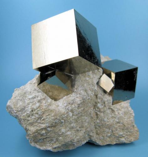 Four undamaged cubic pyrite crystals with mirror-like faces intergrown on a matrix of marlstone.
Overall size: 95 mm x 78 mm.
Main crystal: 31 mm on edge.
Weight: 512 g. (Author: Carles Millan)
