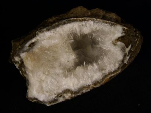 Mordenite
Sgurr nam Boc, Isle of Skye, Scotland, UK
10 cm x 5 cm x 6 cm deep

Mordenite in delicate crystals to 10mm long with a few stilbite crystals, in a quartz-lined cavity in basalt. This zeolite mineral is very silica-rich and to my knowledge is only found at this locality (on Skye, that is), where quartz is plentiful.
Self-collected 1998. (Author: Mike Wood)