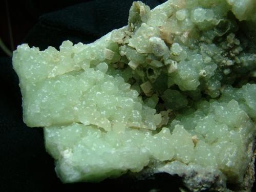 Prehnite
Sgurr nan Cearcall, nr Glen Brittle, Isle of Skye, Scotland, UK
FOV 7cm x 5cm
Nice green and quite lustrous prehnite crystals forming thick crusts in very hard basalt. Open and vuggy material, often with little epimorphs(?) or casts of prehnite on calcite (presumably) to 3mm across, but the casts are hollow.
Self-collected 1997 (Author: Mike Wood)