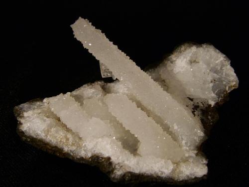 Quartz
Sgurr nam Boc, Isle of Skye, Scotland, UK
5cm x 4cm
Quartz ’stalactite’ 37mm long, with a 3mm heulandite crystal and a tiny stilbite crystal attached.
Self-collected 1994 (Author: Mike Wood)
