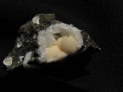 Phillipsite + Levyne
Moonen Bay, Isle of Skye, Scotland, UK
30mm x 20mm x 13mm
Radiating balls of yellow phillipste in a small cavity (13mm x 11mm) with levyne crystals. Rare in this habit.
Self-collected 1997 (Author: Mike Wood)