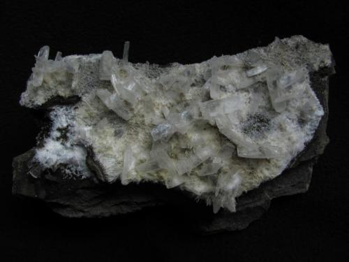 Stilbite + ’Mesolite’
Sgurr nam Fiadh, Isle of Skye, Scotland, UK
9cm x 5cm x 3cm
Unusual stilbite crystals to 13mm long on ’mesolite’ (could be natrolite).
Self-collected 1999 (Author: Mike Wood)