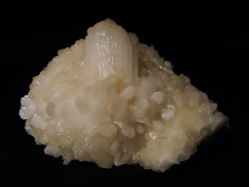 Stilbite
Sgurr nam Boc, Isle of Skye, Scotland, UK
11cm x 7cm x 6cm deep
Large ’wheatsheaf’ single stilbite crystal measuring 70mm x 25mm, with a pink central zone; surrounded by smaller stilbite crystals.
Self-collected 1995 (Author: Mike Wood)