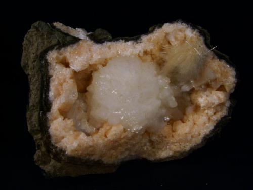 Stilbite + Mesolite + Chabazite
Sgurr nam Boc, Isle of Skye, Scotland, UK
12cm x 9cm x 4cm deep
Colourful specimen of orange/pink chabazite in crystals to 13mm with a 5cm wide aggregate of stilbite crystals in the centre. Accompanied by a nice tuft of mesolite (tested), and a little heulandite just to the left of the stilbite, but hard to see in the photo.
Self-collected 2006 (Author: Mike Wood)