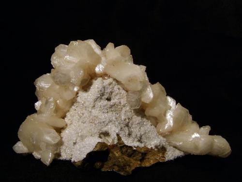 Stilbite
Sgurr nam Boc, Isle of Skye, Scotland, UK
14cm x 8cm x 6cm
Pleasing arrangement of lustrous stilbite crystals draped over a mound of basalt matrix. A thin crust of white laumontite partly covers the matrix.
Self-collected 2001 (Author: Mike Wood)