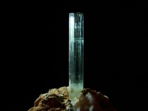 Beryl (var aquamarine)
Lundy Island, Devon, England, UK
27mm x 4mm crystal
Undamaged terminated crystal on quartz/feldspar pegmatitic matrix - repaired at the base ! (After getting it home in one piece)   -_- (Author: Mike Wood)