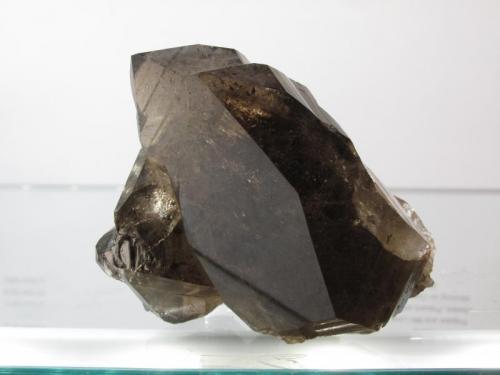 Smoky Quartz
Isle of Arran, Scotland, UK
65mm x 45mm x 45mm
Same specimen as above. The large, smooth crystal face is nearly 5cm long. (Author: Mike Wood)