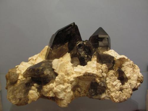 Smoky Quartz + Microcline
Isle of Arran, Scotland, UK
12cm x 7cm x 6cm high
Rare combination specimen. The feldspar crystals are not complete, but the two smokies are pretty good; only the smaller one has a ding on it’s termination. The larger smoky quartz crystal is 57mm tall.
Self-collected. (Author: Mike Wood)