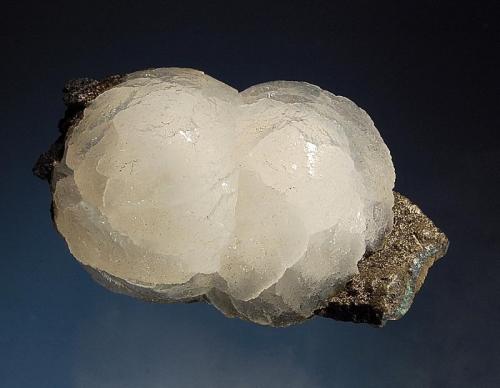 Stellerite
Nasik District, Maharashtra, India
3.5 x 5.7 cm.
Two intergrown hemispheres of pearly-lustered stellerite on a small shard of dark gray basalt. (Author: crosstimber)