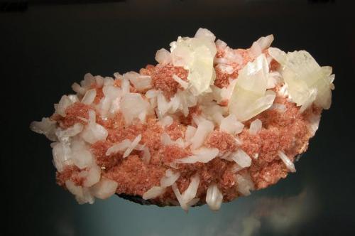 Apophyllite-(KF)
Aurangabad District, Maharashtra, India
8.5 x 15.0 cm.
Colorless crystals of apophyllite with white stilbite crystals, scattered over a thin crust of small reddish-pink heulandite crystals. (Author: crosstimber)