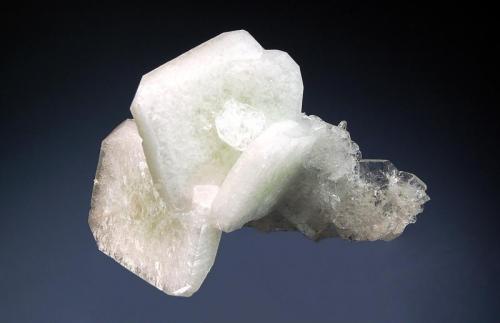 Apophyllite-(KF)
Mahodari Quarry, Nasik District, Maharashtra, India
4.5 x 7.0 cm.
A small group of milky-white, tabular crystals to 3 cm with pale green cores and truncated corners. Collected from a single pocket in 1999. (Author: crosstimber)