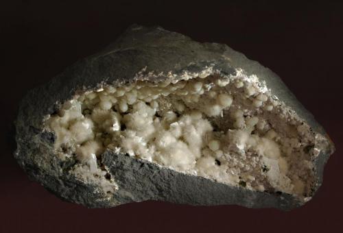 Okenite
Kandivali Quarry, Malad, Mumbai District, Maharashtra, India
17.4 x 29.8 cm.
An elongated cavity in black basalt lined with white spheres of acicular okenite, prismatic white laumontite, and hemispheres of white gyrolite. (Author: crosstimber)