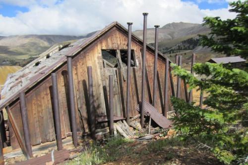 A steam manifold at the rear of the winch house feeds the dual cylinders that power the winch. The view is toward the east and Mosquito Pass. The divide follows the ridge line, there is rain over there. (Author: vic rzonca)