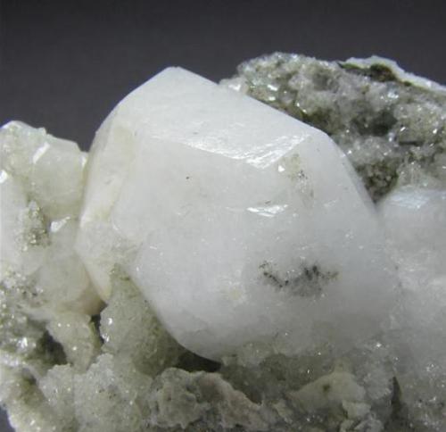 Analcima
Paterson, Passaic Co., New Jersey, EEUU
7,5 x 7,7 x 3 cm
Detalle del cristal principal. Aparecen también pequeños cristales transparentes que pudieran ser de calcita (tendré que mirarlo) (Autor: Antonio Alcaide)