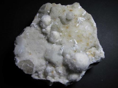 Okenita
Maharashtra, India
10 x 10 cm.
Fragmento de una cavidad en una roca basáltica tapizado por algunos agregados de okenita y una costra cristalina de calcita. (Autor: prcantos)
