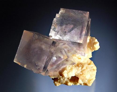 Fluorite
Shangbao Mine, Leiyang Co., Hunan Prov., China
4.5 x 5.0 cm
Pale blue cubic fluorite with purple phantoms resting on a matrix of pale beige dolomite crystals. (Author: crosstimber)