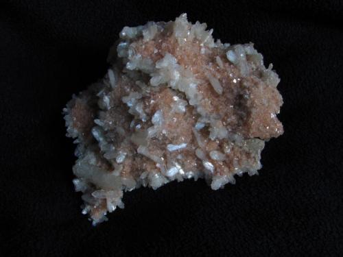 Stilbite + Chabazite
Moonen Bay, Isle of Skye, Scotland, UK
11cm x 10cm x 6cm high
Dome of basalt matrix completely covered with pink chabazite and white stilbite crystals. The underside is fairly flat and more densely covered with ’stubby’ stilbites. The larger stilbite crystal is 30mm long. Self-collected March 2013. (Author: Mike Wood)