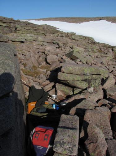 This was my bed for the night before, on a mat in a bivi bag in a rocky niche. I was planning on sleeping on a nice grassy spot around the corner but the wind got up and it was cold, so I moved here for shelter. It was more comfortable than it looks! (Author: Mike Wood)