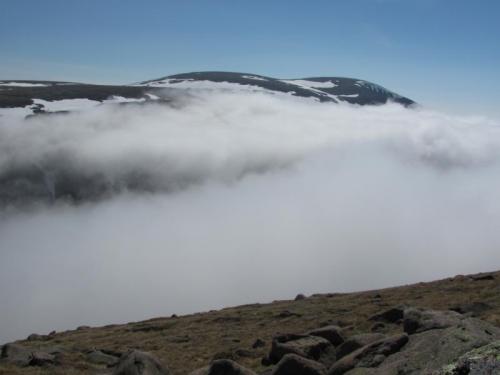 A little over an hour later I was back in the sunshine on the other side of the valley. The mountain in the distance is Ben Macdui, which I traversed the day before in a fruitless search for phenakite. (Author: Mike Wood)