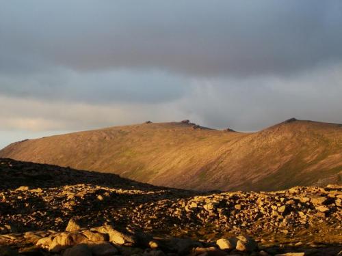 Beinn Mheadhoin (1182m) - pronounced as ’Ben Vane’ - was formerly well known as producing smoky quartz, in the 19th century! I have been over it a couple of times but failed to find anything worth carrying out, except for one single beryl crystal on my first visit in 1994. Photo taken looking East at the mountain, with it’s distinctive ’tors’, in July 2006. (Author: Mike Wood)