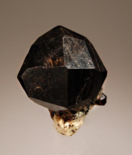 Almandine
Ialamitana pegmatite, Sahanivotry Commune, Antsirabé II Dist., Antananarivo, Madagascar
2.7 x 3.5 cm
A sharp brown almandine trapezohedron with reddish highlights attached to a small piece of light-colored feldspar matrix. (Author: crosstimber)