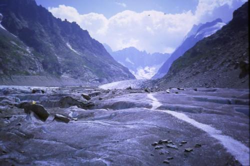 Once on the glacier (Mer de Glace) it is several kilometres walk to some more ladders, to get off the glacier and up the path to the Courvercle Hut below the Aiguille du Moine. The glacier is ’dry’ this low down at this time of year so is mostly easy to walk on - you can see the objective dangers (crevasses) and avoid them. A refreshing cold breeze blows down the valley, otherwise it would be hot under the summer sun.
Photo scanned from slide. (Author: Mike Wood)