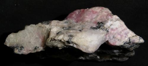Chkalovite, Tugtupite
Ilímaussaq Intrusive Complex, Narsaq, Greenland
(section 10 x 4 cm)
Side view of the previous piece. 
This capture shows the typical appearance of the beryllium silicate Chkalovite: it has a luster somewhat similar to fresh cheese. (Author: kakov)
