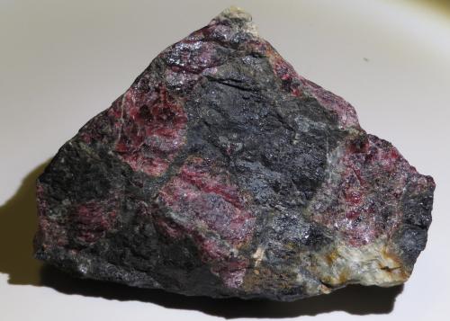 Eudialyte
Kola Peninsula, Rusia
9 x 6 x 4 cm
The other side of the same piece (with light matrix) on the previous photo. 

This is one of the classic minerals of alkaline sites. It looks like garnet but have a completely different composition and structure, its hardness is also considerably lower than garnet. (Author: kakov)