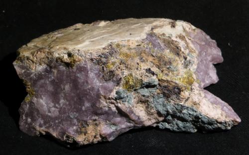 Ussingite, Vuonnemite, Sphalerite
7 x 4,5 x 3 cm
Lovozero Massive, Kola Peninsula, Russia
Probably from the Shkatulka pegmatite - to be confirmed. 
The purple material is the Ussingite; they yellow plate on the top is Vuonnemite, Sphalerite is seen as bright yellow grains in the Ussingite. The small black dots might be Steenstrupine-(Ce), that is much less common in the Kola intrusions than in Ilímaussaq. (Author: kakov)