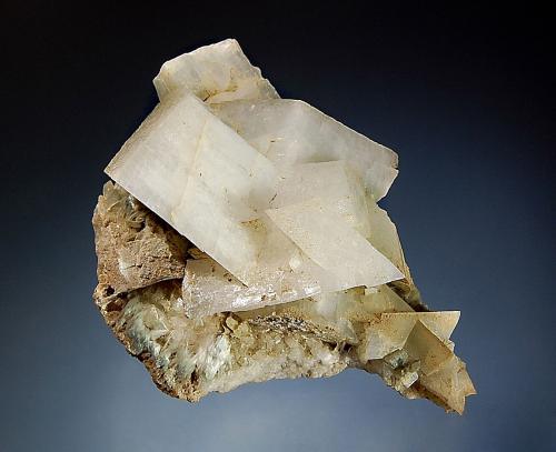 Orthoclase var. adularia
Tyrol, Austria
7.1 x 9.3 cm
Colorless adularia crystals associated with fibrous white to greenish byssolite. (Author: crosstimber)