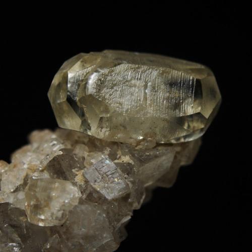 Twinned calcite crystal on fluorite
Longstone Edge, Derbyshire, England, UK
Calcite twin ~ 10 mm long. Collected 22/08/1998 from a limestone boulder at the side of the access road leading to the then active workings on the Bow and Deep Rake veins. (Author: Andy Lawton)