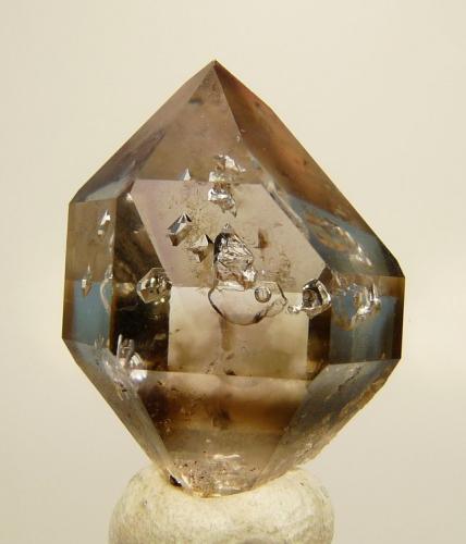 Quartz var. smoky
Brandberg, Erongo, Namibia
23 x 15 x 15 mm
A neat light smoky crystal with inverted crystals and water. (Author: Pierre Joubert)