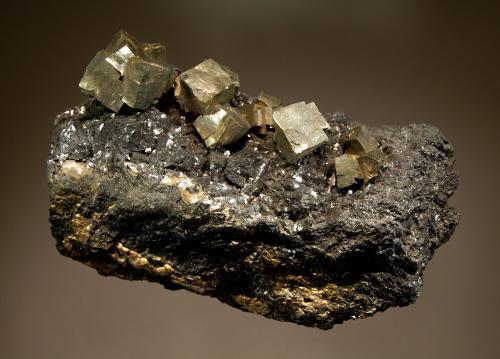 Pyrite
French Creek Mines, St. Peters, Chester County, Pennsylvania, USA
4.3 x 8.5 cm
Brassy, cubic pyrite crystals with unusual curved edges on platy to granular, massive black magnetite (Author: crosstimber)