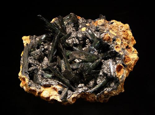 Vivianite
Kamysh-Burun Trough, Kerchenskoe deposit, Crimea Peninsula, Crimea Oblast, Ukraine
5.6 x 6.3 cm
Sprays of dark green bladed vivianite resting on a thin layer of oolitic black limonite covering a brown gossan matrix. (Author: crosstimber)