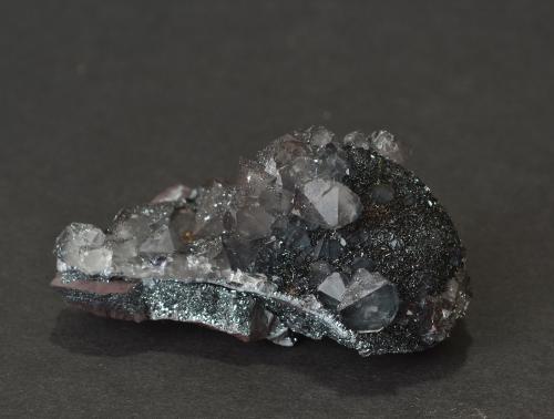 Quartz (var. smokey) on hematite (var. specularite) on plate
Haile Moor Mine, Haile, Egremont, Cumbria, England, UK
5.8 x 2.9 x 3.0 cm
93g. This piece is from the Bucks Head Inn collection in the village of Haile. The collection was assembled by the local miners swapping specimens for pints of ale! Ex. Ralph Sutcliffe specimen with label. (Author: captaincaveman)
