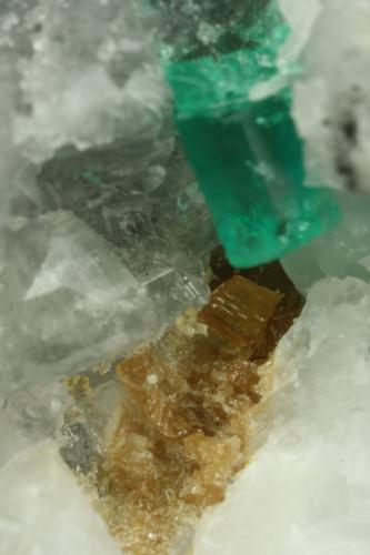 Beryl (variety emerald), Calcite, Parisite<br />Muzo mining district, Western Emerald Belt, Boyacá Department, Colombia<br />FOV=8mm<br /> (Author: Fiebre Verde)