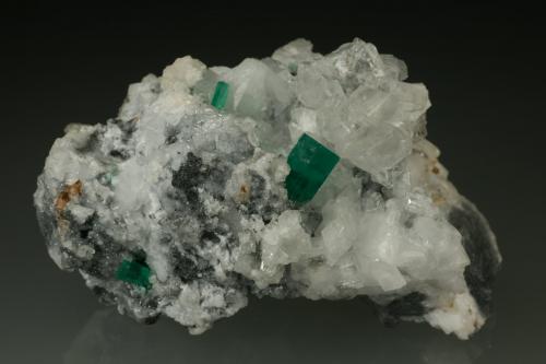 Beryl (variety emerald), Calcite, Parisite<br />Muzo mining district, Western Emerald Belt, Boyacá Department, Colombia<br />70x45x50mm<br /> (Author: Fiebre Verde)