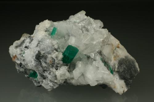 Beryl (variety emerald), Calcite, Parisite<br />Muzo mining district, Western Emerald Belt, Boyacá Department, Colombia<br />70x45x50mm<br /> (Author: Fiebre Verde)