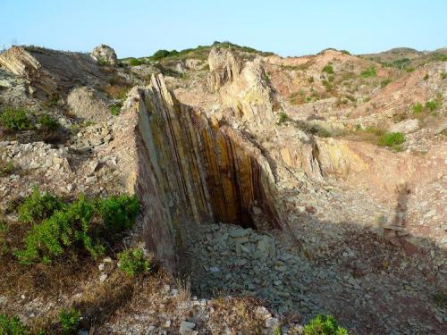 Caliza. Otras pequeñas canteras artesanales. De esta corta sale actualmente la piedra de mejor calidad: grande, lisa y uniforme. Las capas finas (1 – 2 cm) se usan para revestimientos verticales y las mas gruesas para solería. La mayor parte de la producción se vende tal cual sale, con contorno irregular, aunque por encargo las mejores losas se trabajan a cincel hasta dejarlas a medida. (Autor: Josele)