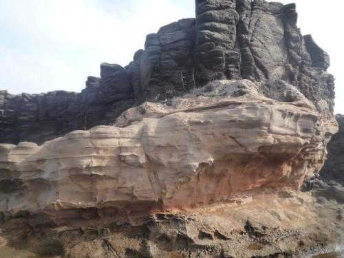 Estratos de toba soportando una colada basáltica
La Isleta, Gran Canaria, España
Como referencia, salen los muslos de una señora en el extremo inferior derecho (Autor: María Jesús M.)