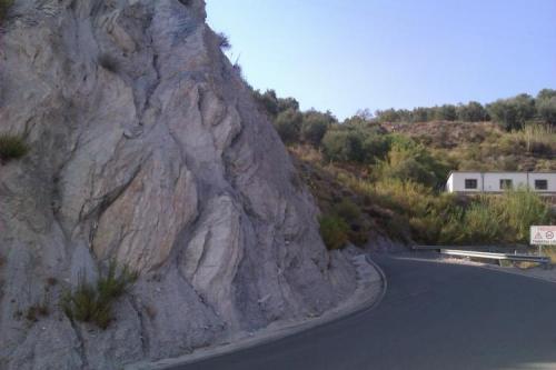 Filonita (esquisto milonítico).Afloramiento donde aparece la roca anterior.
Picena (Granada, España)
Obsérvense los derrubios al pie del talud de la carretera, debidos a la gran deleznabilidad de la roca, unos pocos metros al sur de Picena. (Autor: prcantos)